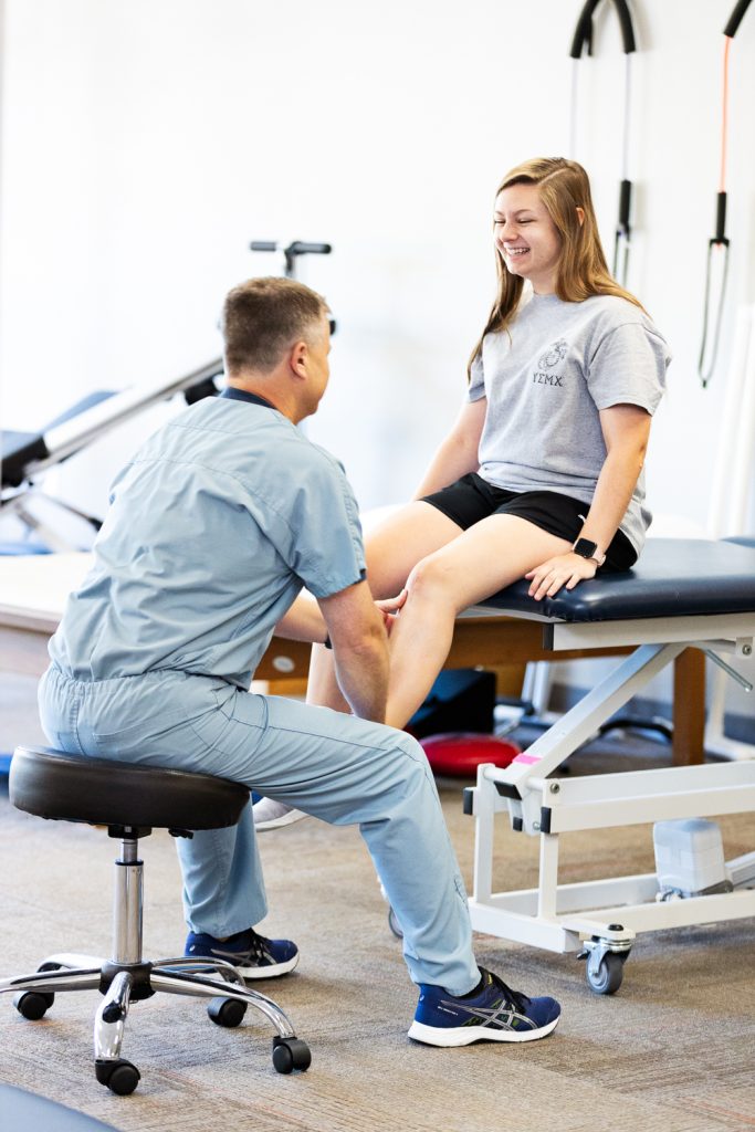 Physical Therapist working on patient with knee injury